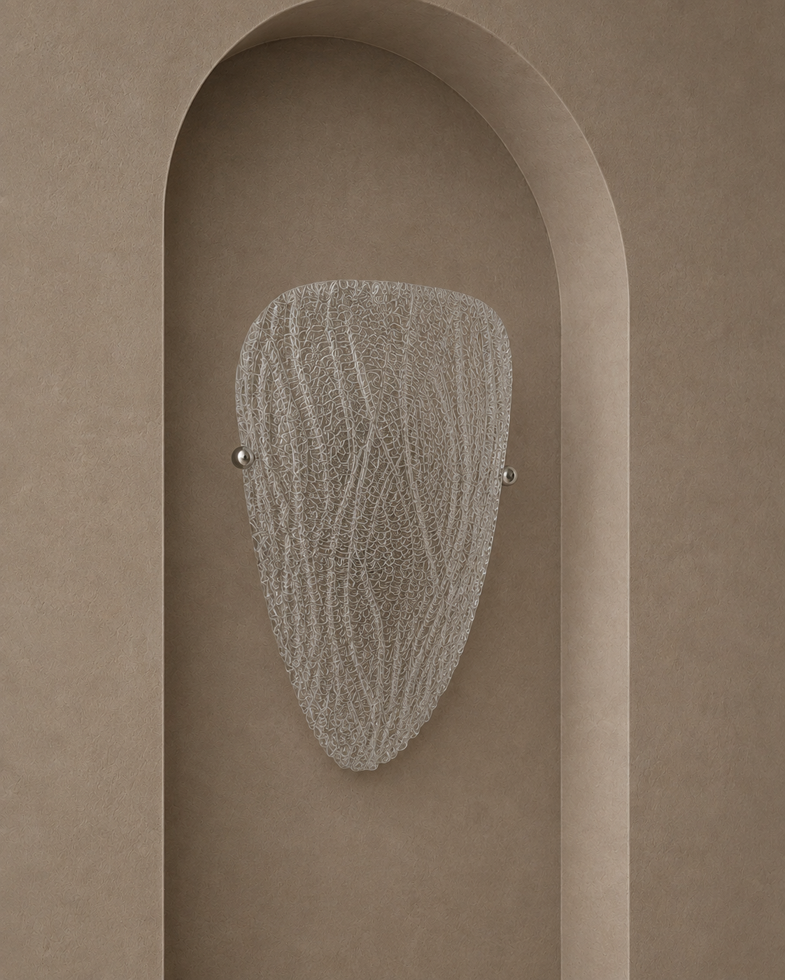 A modern wall sconce with a textured, organic-shaped frosted glass shade and two small silver metal balls on either side, mounted on a warm beige plaster wall with an arched recess.
