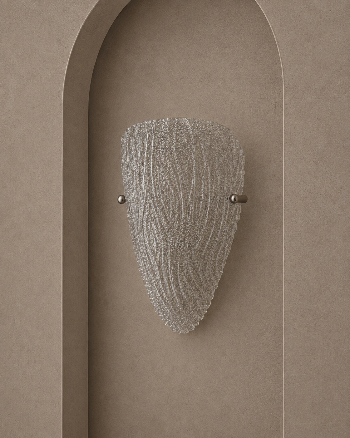 A modern wall sconce with a textured, ribbed clear glass shade and brushed metal hardware, mounted on a warm beige plaster wall with an arched recess.
