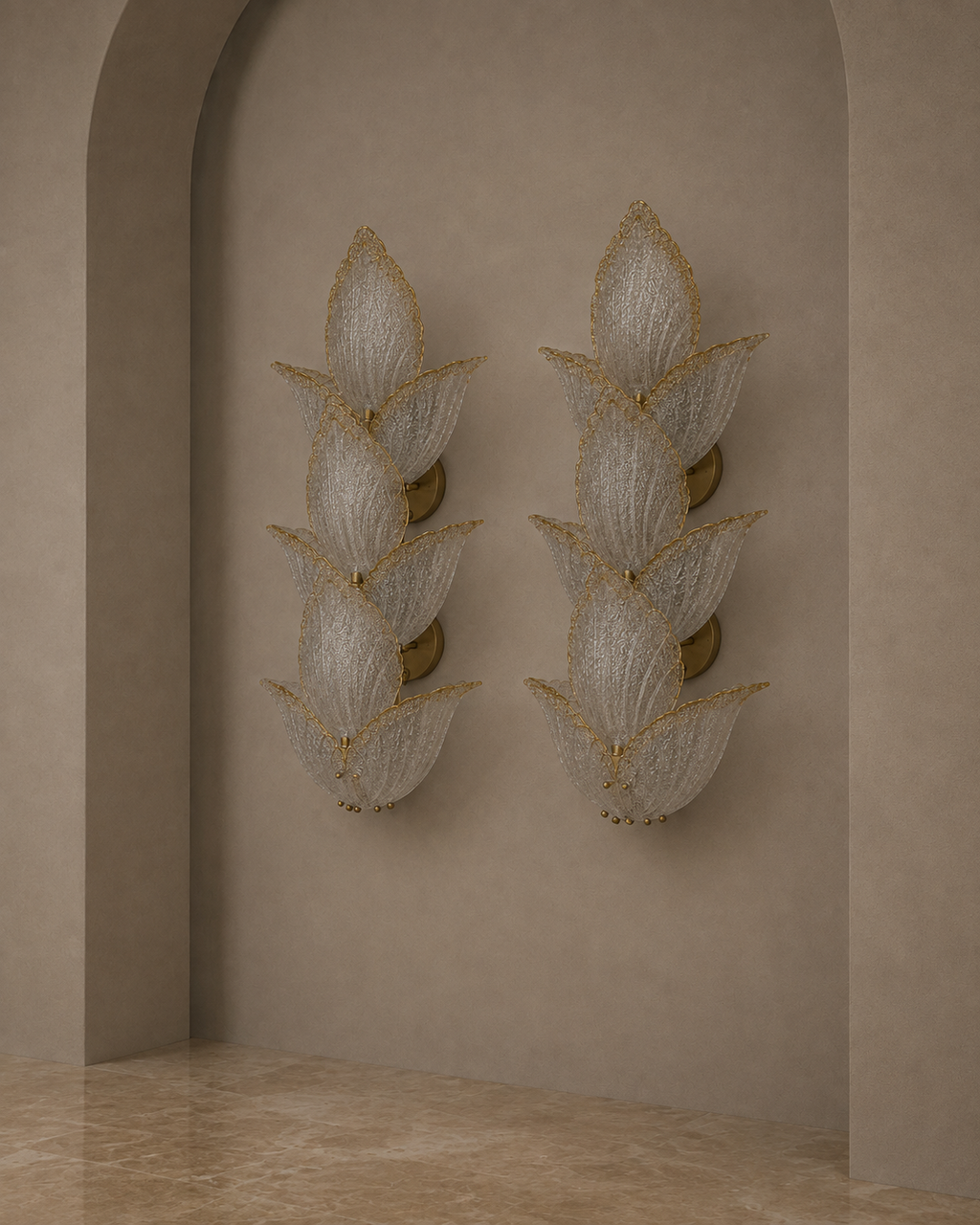 Two matching wall sconces with layered translucent white petal-like shades and gold trim, mounted on a beige plaster wall in an arched alcove with a stone floor.