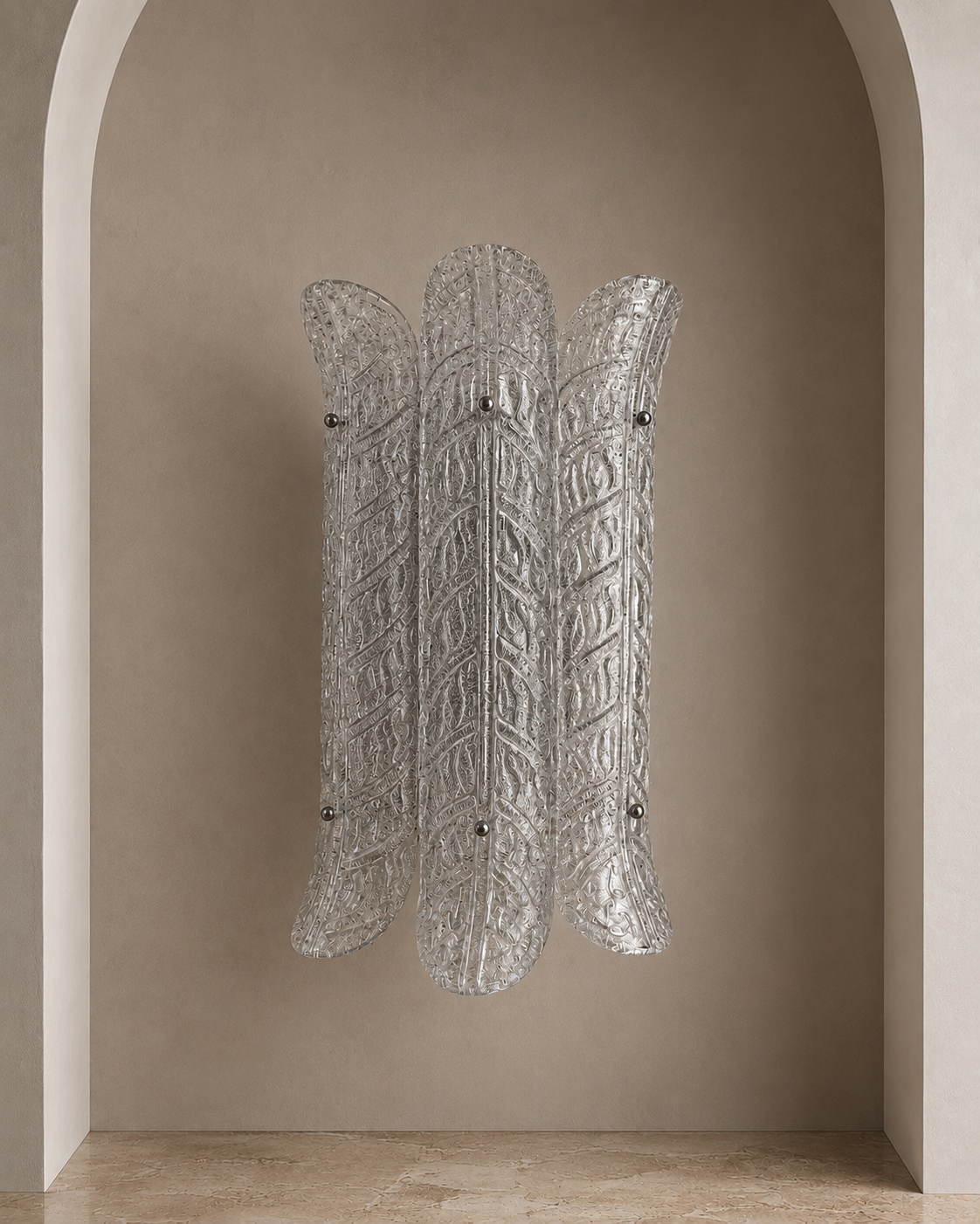 A sculptural wall sconce made of textured, ribbed clear glass, mounted on a warm beige plaster wall within an arched alcove.