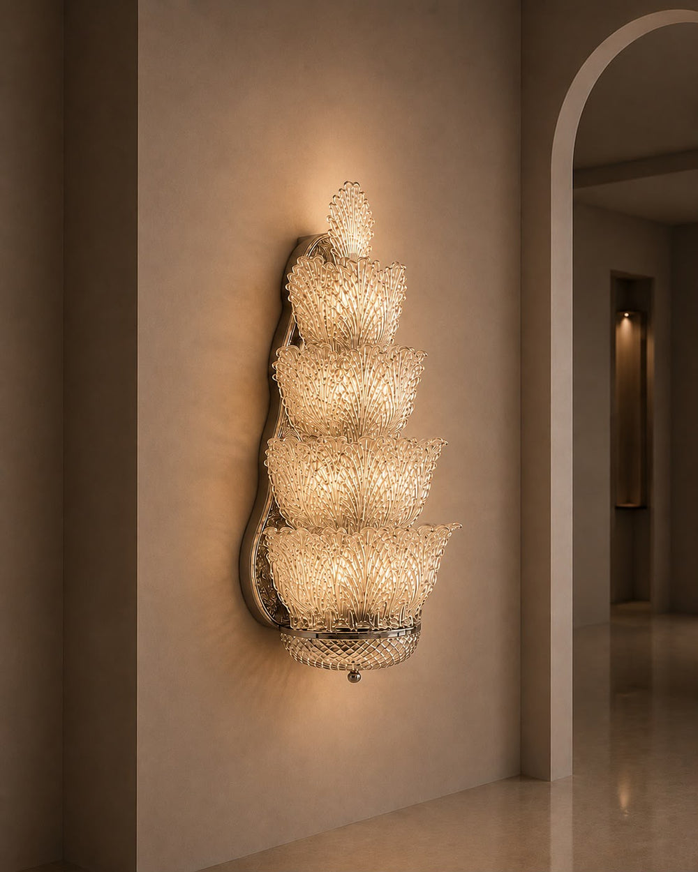 A modern wall sconce with five stacked, tiered crystal-like shades mounted on a beige plaster wall in an elegant interior hallway.