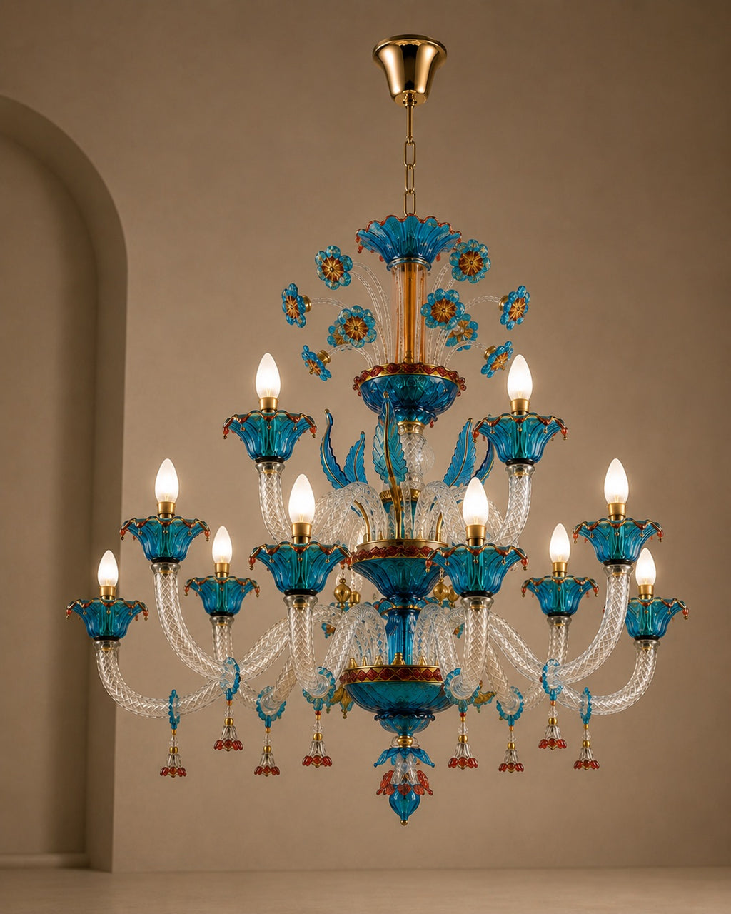 A multi-tiered chandelier with blue glass flower petals, clear crystal arms, and gold-toned metal hardware, shown hanging against a beige wall.