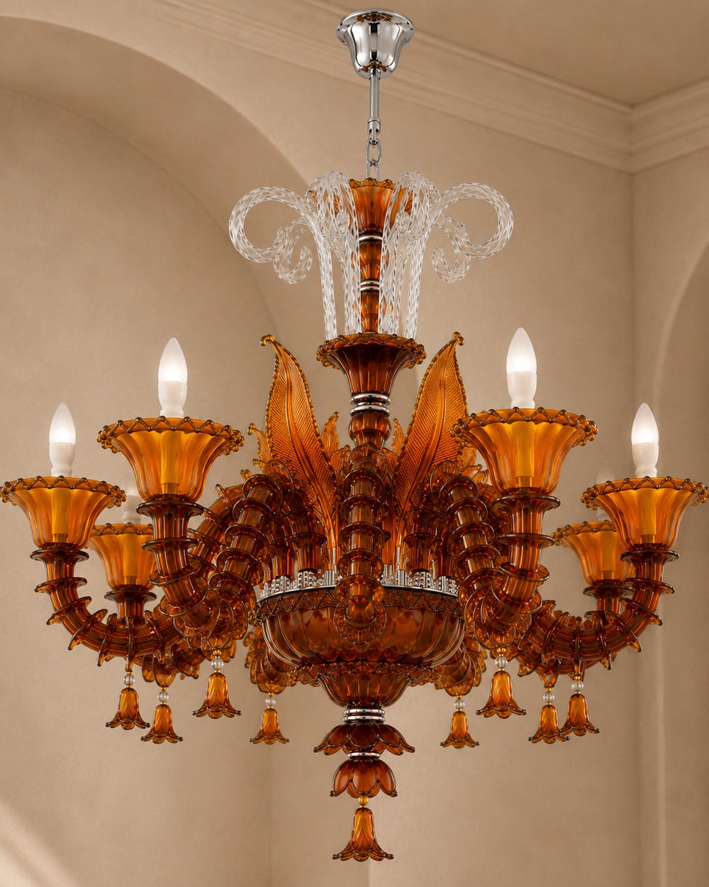 An ornate amber glass chandelier with multiple candle-style lights, hanging from a ceiling in a warm beige interior.